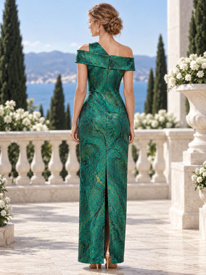 Back view of an emerald green and gold jacquard satin mother of the bride dress featuring an asymmetric shoulder construction, fold-over off-shoulder neckline, center-back closure and fitted floor-length sheath silhouette.