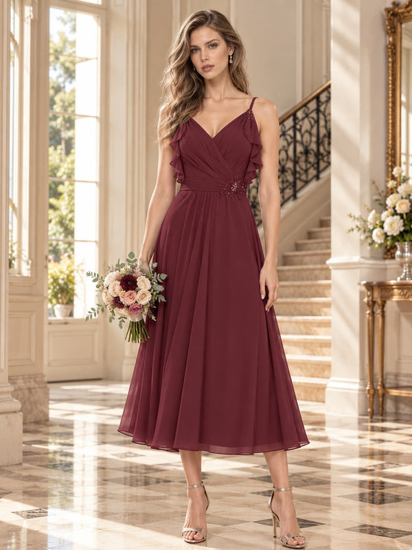 Chiffon A-line V-neck midi mother of the bride evening dress with ruffle straps and floral waist detail, front view.