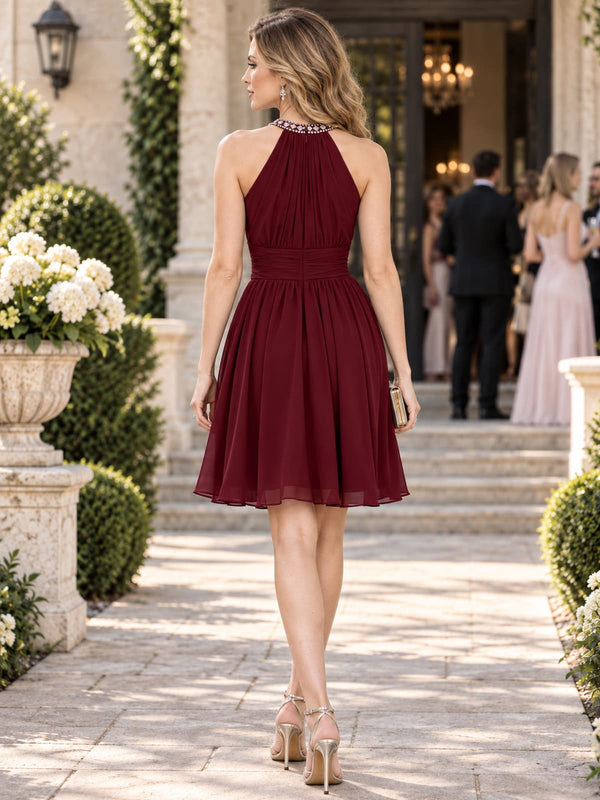 Back view of a chiffon A-line mother of the bride dress with embellished halter neckline, fitted ruched waist and knee-length skirt.