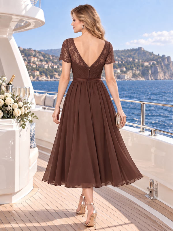 Back view of a lace chiffon A-line mother of the bride dress with deep V-back, short lace sleeves, defined waistband and midi skirt.