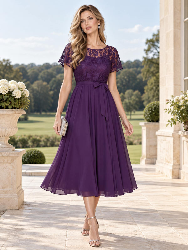 Front view of a floral lace chiffon A-line mother of the bride dress with illusion bateau neckline, short sleeves, waist sash and tea-length skirt.