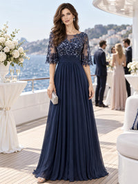 Front view of a floral lace chiffon A-line mother of the bride dress with illusion neckline, lace sleeves and ruched waist.