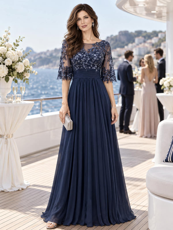 Front view of a floral lace chiffon A-line mother of the bride dress with illusion neckline, lace sleeves and ruched waist.