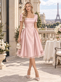 Front view of a satin A-line mother of the bride dress with square neckline, short sleeves and 3D floral tea-length hem.